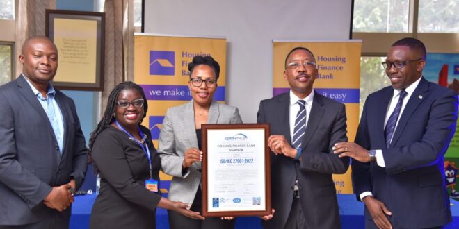 Top Housing Finance Bank and Certi-Trust executives pose for a group photo with the ISO certificate during the handover in Kololo
