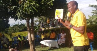 Bamuturaki showing his supporters the manifesto book which was given by the NRM party chairman c